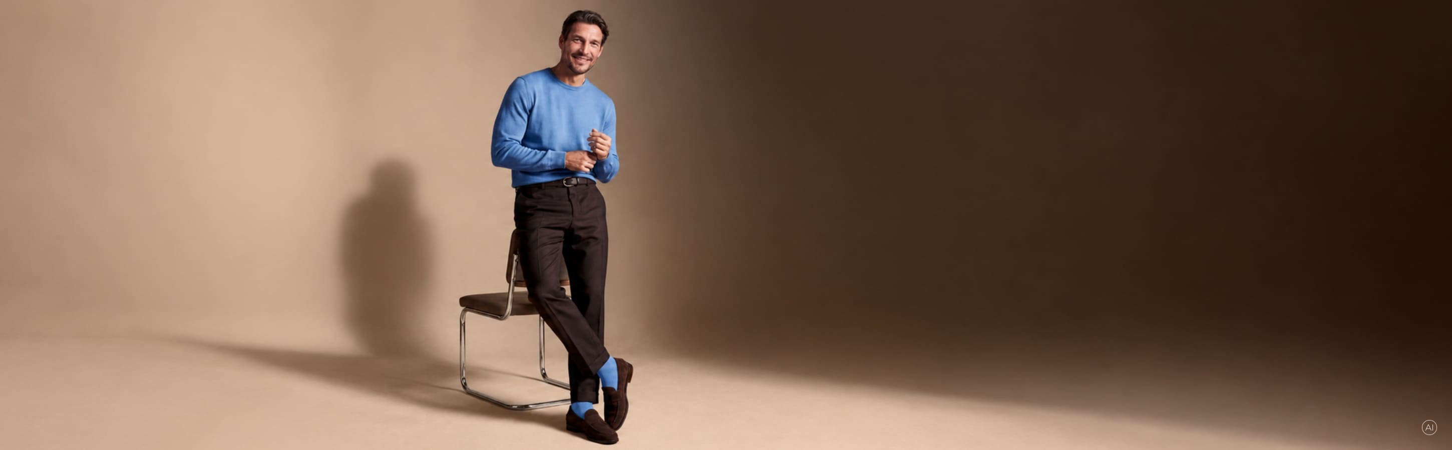 Elegant gekleideter Mann in blauem Pullover und dunkler Hose mit blauen FALKE Socken. Das Bild ist KI generiert