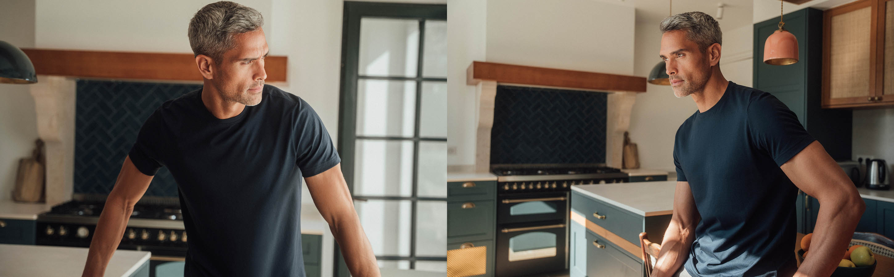 Ein Mann lehnt vor der Küchenzeile. Er trägt ein dunkelblaues Essential T-Shirt von FALKE aus Pima-Baumwolle.