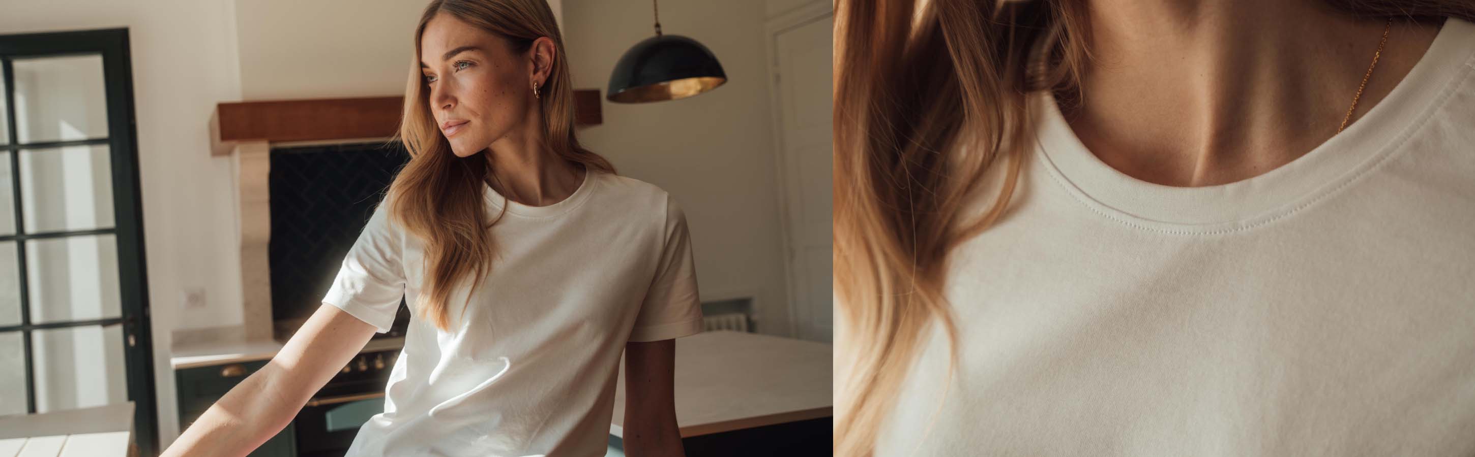 Eine Frau lehnt vor der Küchentheke und schaut nach rechts. Sie trägt ein weißes Essential T-Shirt von FALKE aus Pima-Baumwolle.