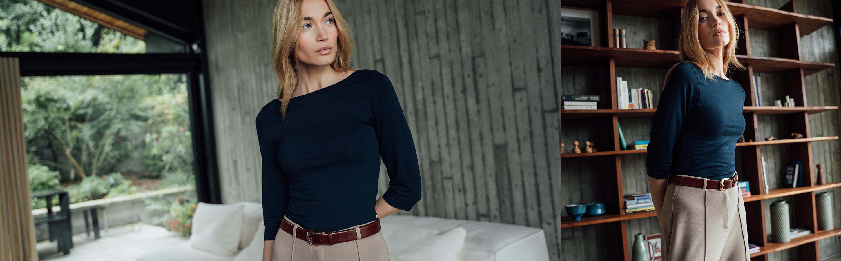 Pima Stretch Shirt für Damen Frau trägt dunkelblaues Dreiviertelarmshirt und beige Hose in modernem Wohnambiente.