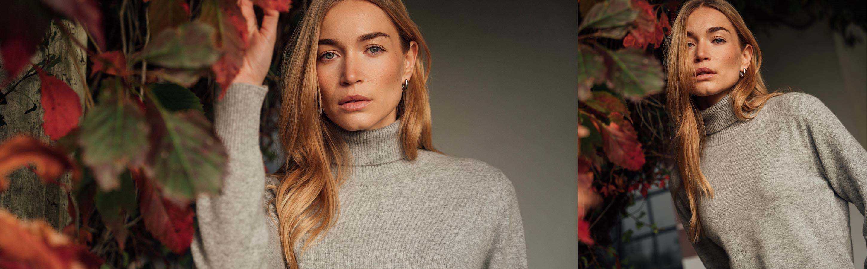 Cashmere Rollkragen für Damen Frau trägt grauen Cashmere Rollkragenpullover vor herbstlichem Laub.
