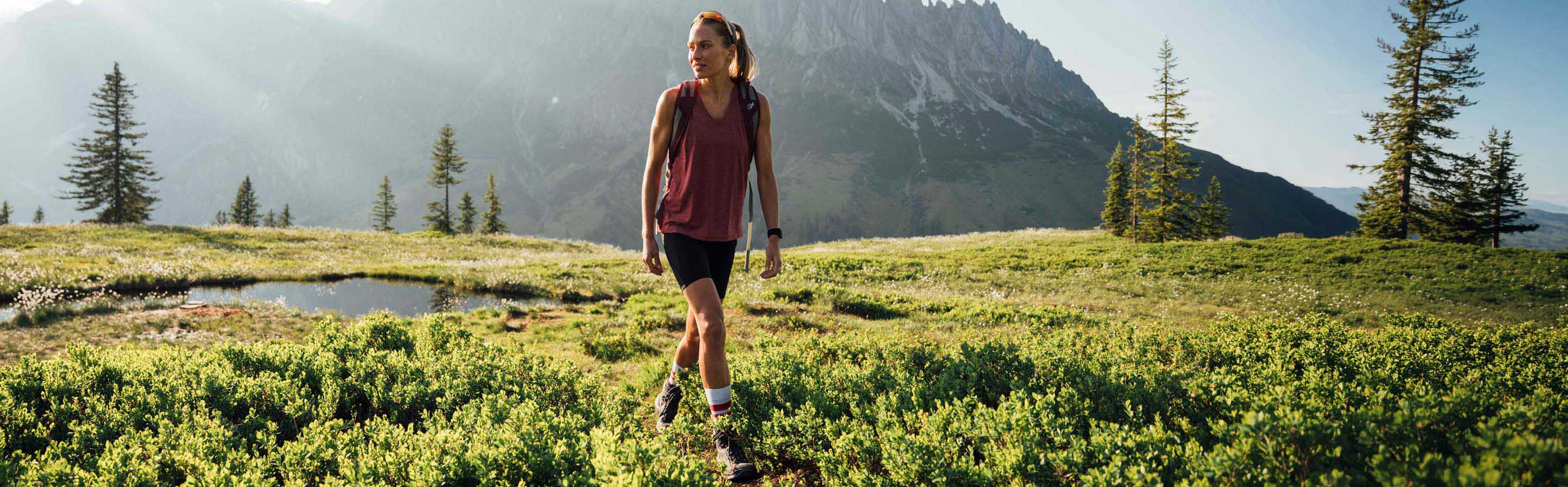 Sportliche Frau beim Wandern in alpiner Landschaft mit FALKE Damen Trekking Socken TK2 Explore