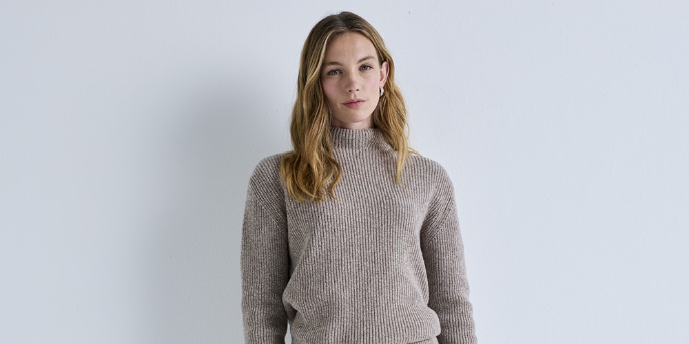 Frau trägt beigen FALKE Strickpullover aus feiner Wolle – eleganter, gemütlicher Damenpullover für Herbst und Winter